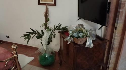 a living room with flowers in a vase and a tv at AL CANTINONE in Toffia