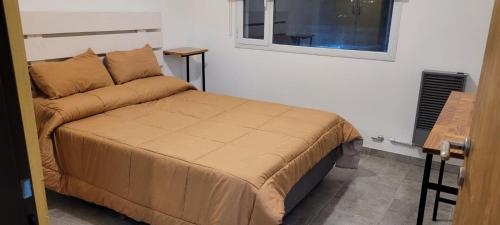 a bedroom with a bed and a window at Departamento familiar in Caleta Olivia