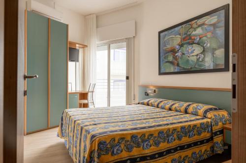 a bedroom with a bed and a painting on the wall at Hotel Continental in Caorle