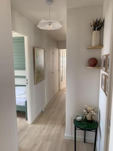 - un couloir avec une chambre dotée d'un lit et d'une table dans l'établissement Bel appartement , vue panoramique, refait à neuf, à Neufchâtel-Hardelot
