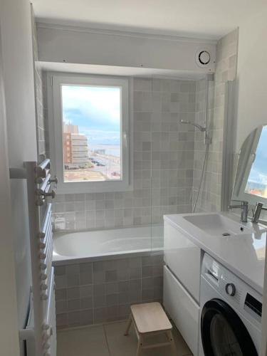 une salle de bain avec une baignoire, un lavabo et une fenêtre dans l'établissement Bel appartement , vue panoramique, refait à neuf, à Neufchâtel-Hardelot