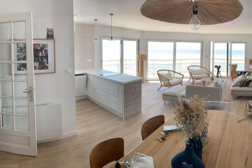 une cuisine et un salon avec une table et un canapé dans l'établissement Bel appartement , vue panoramique, refait à neuf, à Neufchâtel-Hardelot