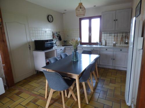 une cuisine avec une table et des chaises dans une cuisine dans l'établissement Terre et Mer, maison avec jardin, à Quend