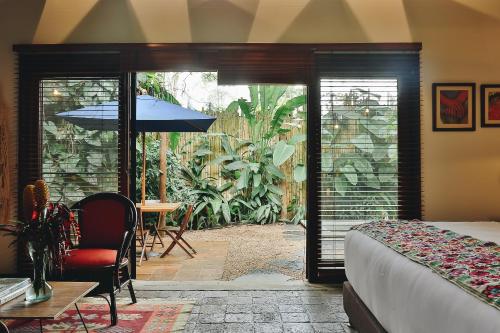 a bedroom with a bed and a patio with an umbrella at Sazagua Hotel Boutique in Pereira