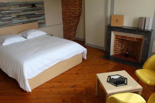 - une chambre avec un lit blanc et une cheminée dans l'établissement Le Clos Saint-Clair Etretat, à Bordeaux-Saint-Clair