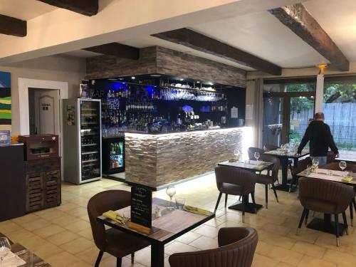 un ristorante con tavoli e sedie e un bar di auberge du castellas a Sainte-Croix-de-Verdon