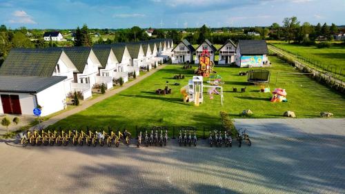 una vista aerea di un gruppo di case e di un parco giochi di Słonecznikowa Dolina a Sarbinowo