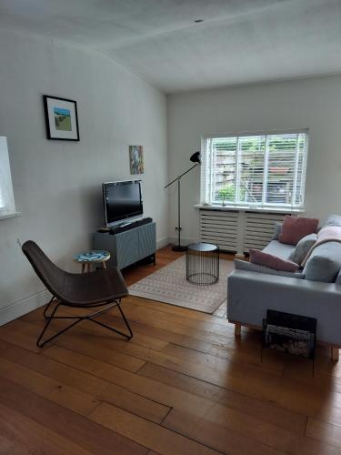 a living room with a couch and a television at Solstice, quiet cottage in Bruinisse, Zeeland in Bruinisse