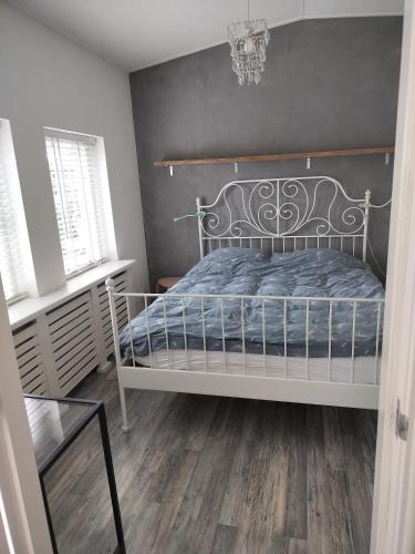 a bedroom with a white bed and a black wall at Solstice, quiet cottage in Bruinisse, Zeeland in Bruinisse
