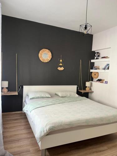 ein Schlafzimmer mit einem großen Bett und einer schwarzen Wand in der Unterkunft Apartment Rose Pula in Pula