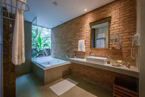 a bathroom with a tub and a sink and a mirror at Hotel Canto das Águas - Roteiro de Charme in Lençóis