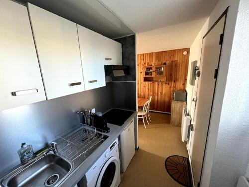 une cuisine avec un évier et une machine à laver dans l'établissement St-Pierre-La-Mer, bel appartement a dans residence avec piscine et tennis entre 5 et 10 min de la plage, à Fleury