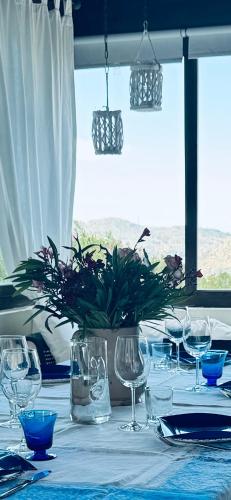 a table with glasses and a vase with a plant on it at Gio Country House in Nicosia