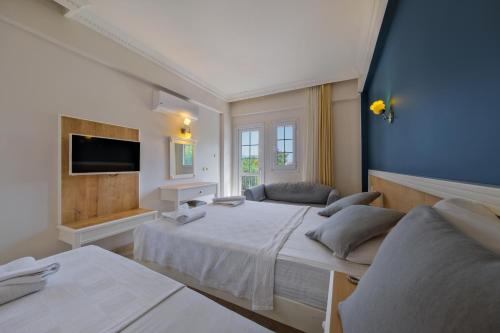 ein Hotelzimmer mit 2 Betten und einem TV in der Unterkunft Majestic Hotel in Oludeniz