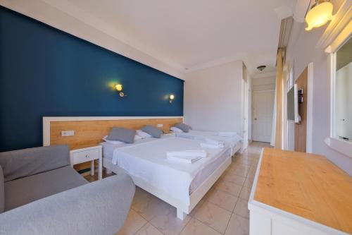 a bedroom with four beds and a blue wall at Majestic Hotel in Oludeniz