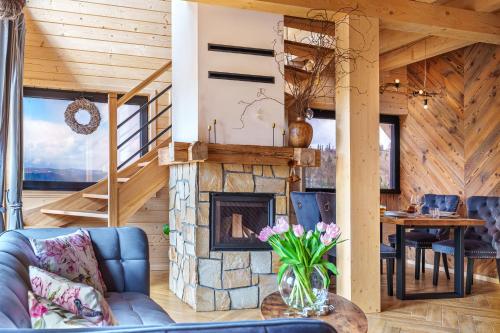 a living room with a fireplace and a table at Alpen House in Dursztyn