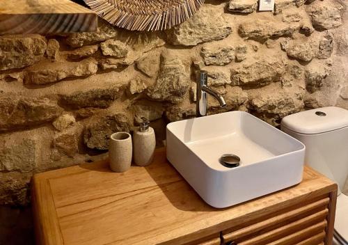 a bathroom with a sink and a stone wall at Quinta Dormmimo a Hidden Gem with Pool near Tomar in Fonte da Laje