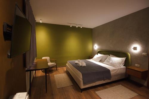 a bedroom with a bed and a green wall at Castlefront Villa in Gjirokastër