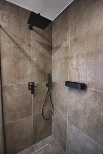 a bathroom with a shower with a shower head at Castlefront Villa in Gjirokastër