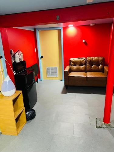 a living room with a couch and red walls at Single Room with Bathroom in Irvington