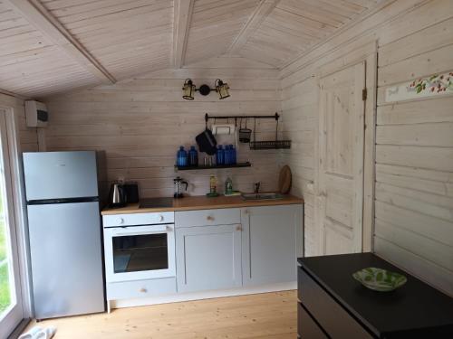 a kitchen with white cabinets and a white refrigerator at Salu summer cottage in Vadi