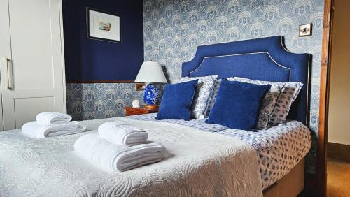 een blauwe slaapkamer met een bed met handdoeken erop bij The Bank - Period Cottage in Picturesque Village 