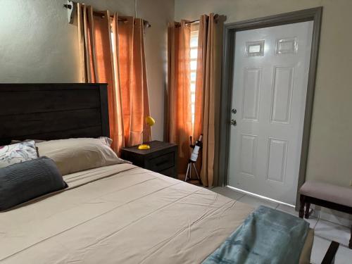 - une chambre avec un grand lit et une porte blanche dans l'établissement JJs Flat, à Cedar Grove