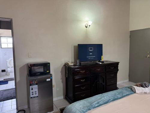 ein Schlafzimmer mit einem TV und einer Kommode mit einem TV darauf in der Unterkunft JJs Flat in Cedar Grove