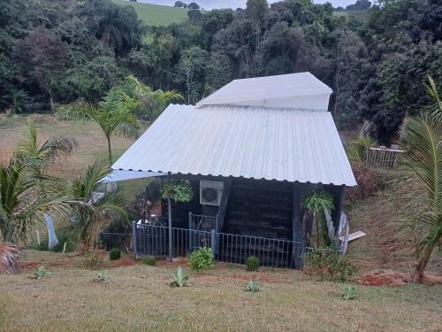a small hut with a tin roof in a field at Casa aconchegante in Bragança Paulista