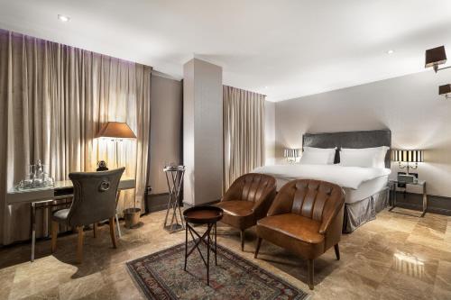 a hotel room with a bed and a desk and chairs at Hotel B Berdichevsky in Tel Aviv