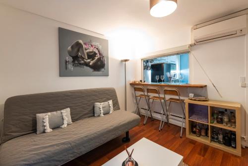 un salon avec un canapé et un bar dans l'établissement Montmartre-Appartement climatisé -3min Sacré-Cœur, à Paris