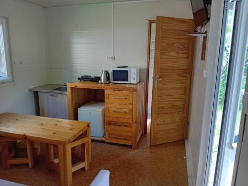 a small kitchen with a table and a microwave at Domek 1 in Dębki