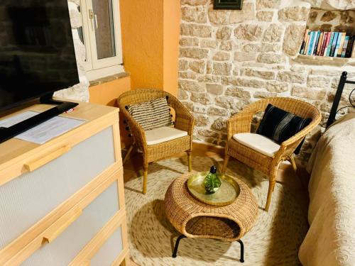 a room with a bed and two chairs and a table at Romantic studio old town in Vrsar