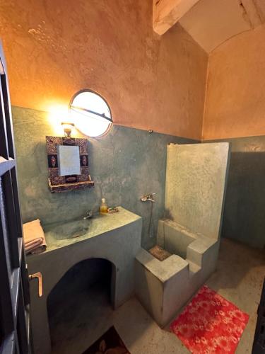 a bathroom with a sink and a toilet and a mirror at La Maison Haute Larache Morocco in Larache