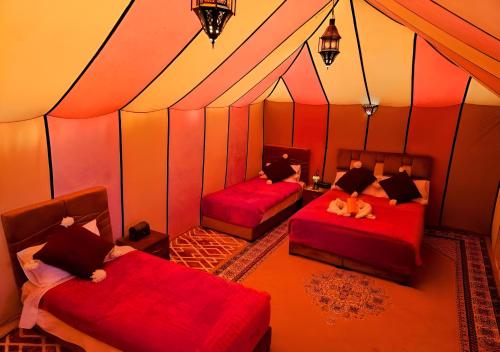 a room with two beds in a tent at Merzouga Lovely Luxury Camp in Merzouga