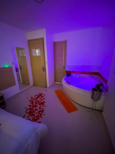 a purple room with a bath tub with a rug at Hotel Cabreromar in Cartagena de Indias