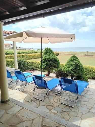 a row of blue chairs and an umbrella at Luxury Villa Ntina in Maronia