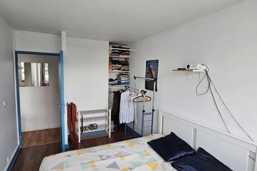 - une chambre avec un lit et une chambre avec un placard dans l'établissement Appartement Pantin - Soutar Prestige, à Pantin