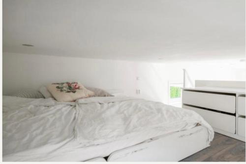 a white bedroom with a bed and a dresser at Fresh happy little house, 35 m2 IN Täby in Stockholm