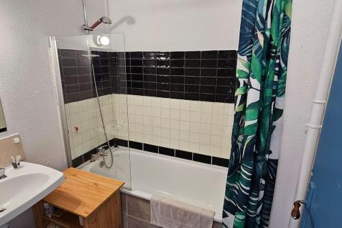 une salle de bain avec une baignoire et un lavabo dans l'établissement Appartement Pantin - Soutar Prestige, à Pantin