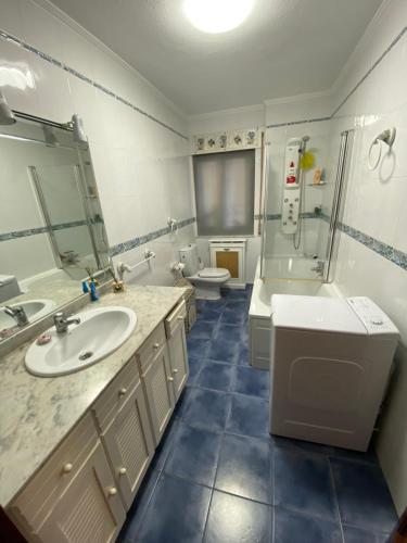 a bathroom with a sink and a shower and a toilet at Apartamento Las Torcas en Mogro in Mogro