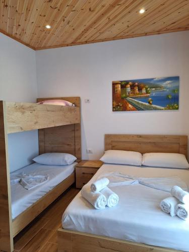 a bedroom with two beds and a painting on the wall at Xuxi Apartments in Lukovë