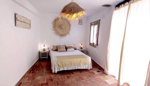 a bedroom with a bed and a chandelier at El Romeral in Fuenterrobles