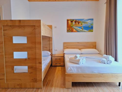 a bedroom with two beds and a mirror at Xuxi Apartments in Lukovë
