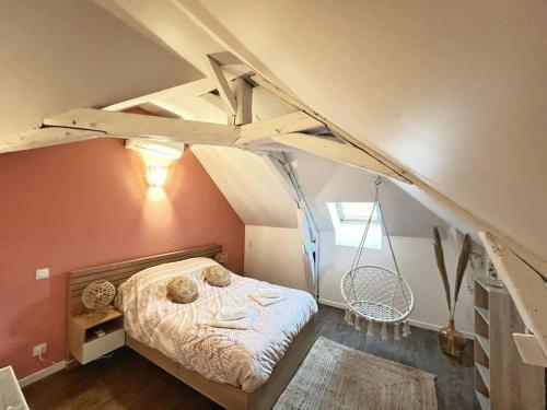 une chambre avec un lit avec une balançoire dans le grenier dans l'établissement Gîtes atypique champenois, à Saint-Martin-dʼAblois