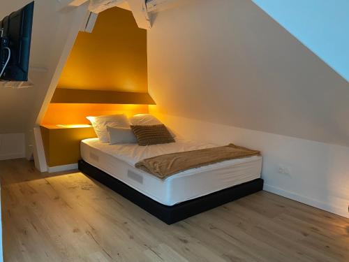 a small bed in a room with an attic at Gîte familial entre Chambord et Beauval in Cour-Cheverny