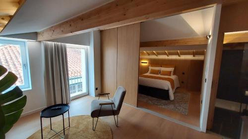 a bedroom with a bed and chairs in a room at Casa das Flores in Bragança