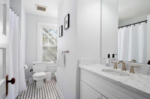 La salle de bains blanche est pourvue d'un lavabo et de toilettes. dans l'établissement 388 Main Street Chatham Cape Cod - - The Priscilla House, à Chatham