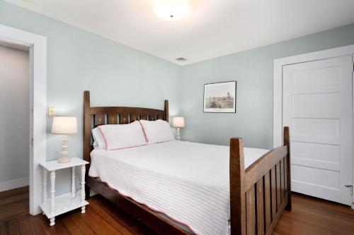 - une chambre avec un grand lit et une tête de lit en bois dans l'établissement 388 Main Street Chatham Cape Cod - - The Priscilla House, à Chatham