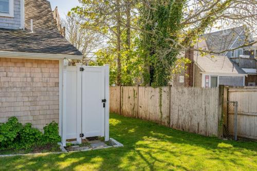 a white door in a yard next to a fence at 388 Main Street Chatham Cape Cod - - The Priscilla House in Chatham